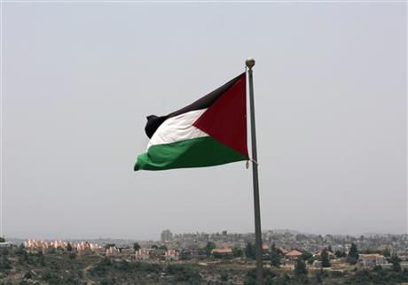 Israeli settlement Ateret in background as the Palestinian national flag flies from the highest point of Rawabi