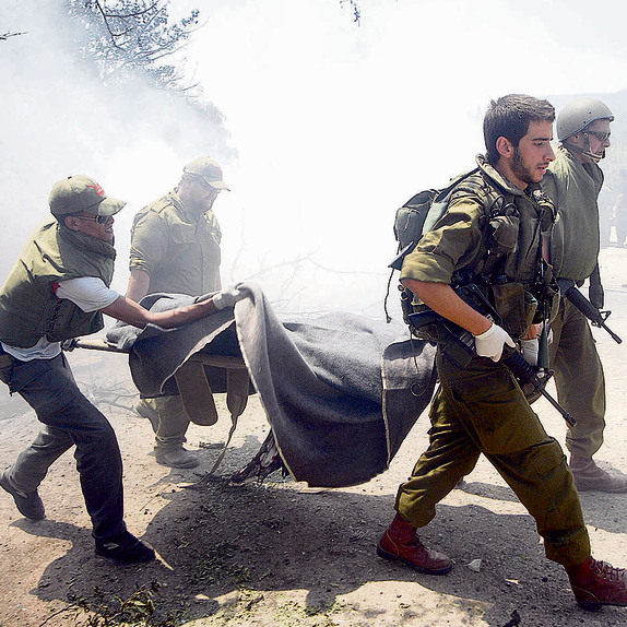 ה־ 6 באוגוסט, 2006 . פינוי פצועים מזירת האסון בכפר־גלעדי. "אין לנו את מי להאשים, הקטיושה הייתה יכולה ליפול בכל מקום" | צילום: אביהו שפירא ה־ 6 באוגוסט, 2006 . פינוי פצועים מזירת האסון בכפר־גלעדי. "אין לנו את מי להאשים, הקטיושה הייתה יכולה ליפול בכל מקום" | צילום: אביהו שפירא