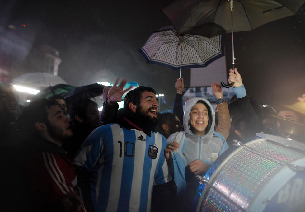 אוהדי ארגנטינה בגשם עם חולצות הנבחרת (צילום: AFP) (צילום: AFP)