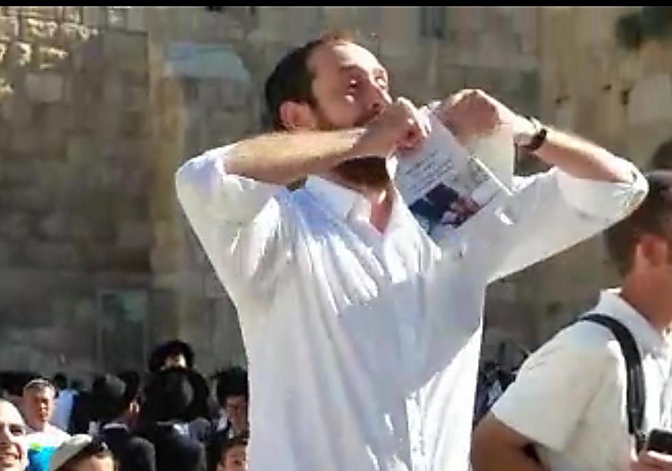 The man ripping the prayer book (Photo: Oshrat Ben Shimshon)