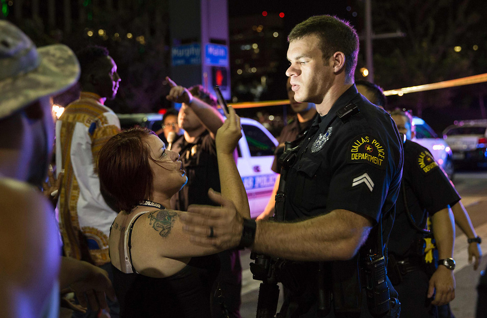 שוטר מרגיע מפגינה. טראמפ: "אנחנו מפולגים מדי" (צילום: AFP) (צילום: AFP)