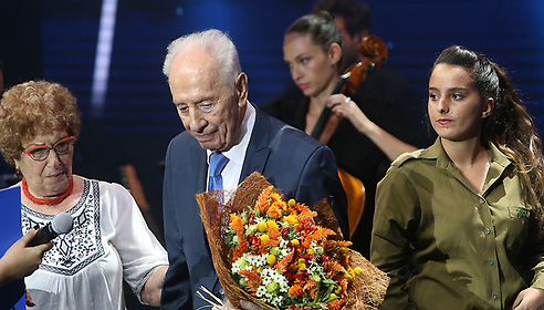 שר הביטחון בזמן המבצע, שמעון פרס, מקבל פרחים מהמשוחררים (צילום: אלכס קולומויסקי)