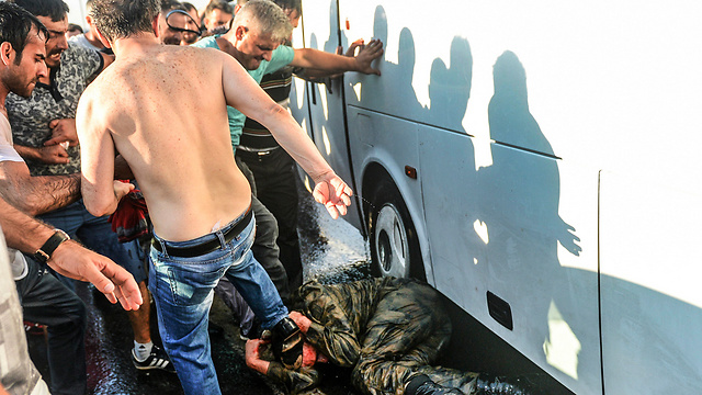חייל שהואשם במעורבות בניסיון ההפיכה מוכה על-ידי ההמון (צילום: AP) (צילום: AP)