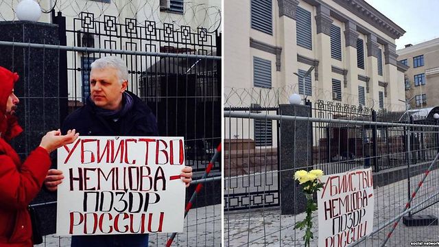 פאבל שרמט עם שלט בידיו שעליו נכתב "הרצח של בוריס נמצוב - הבושה של רוסיה" ()