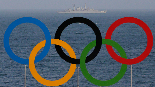 אוניית קרב על רקע הטבעות האולימפיות בחוף (צילום: AP) (צילום: AP)