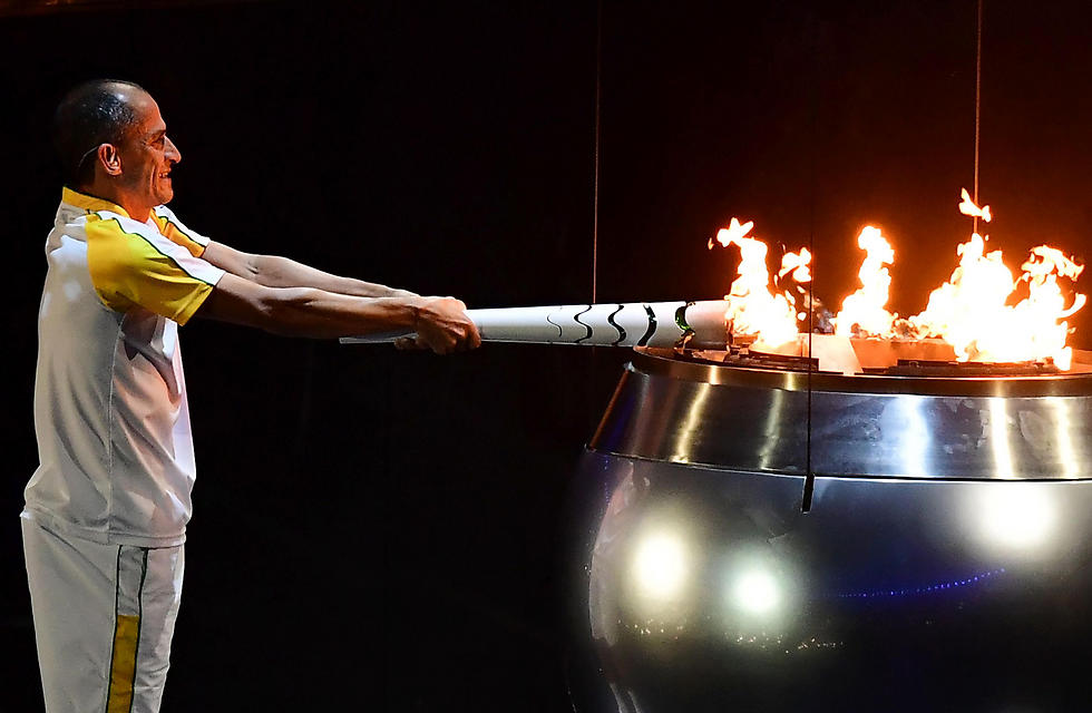 Brazilian marathon runner Vanderlei Cordeiro de Lima, lighting the olympic torch. (Photo: AFP)