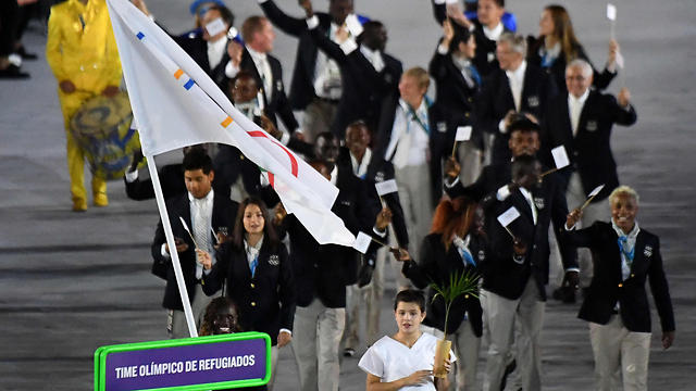 המשלחת צועדת תחת הדגל האולימפי (צילום: AFP) (צילום: AFP)