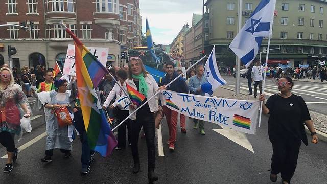 Israeli, Swedish, and LGBT Pride flags at Malmo Pride March