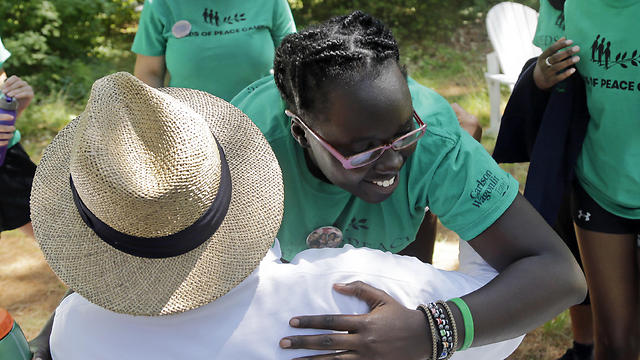 Second-year camper, Ludya, hugs Tim Wilson, special advisor, to the Seeds of Peace camp (Photo: AP)