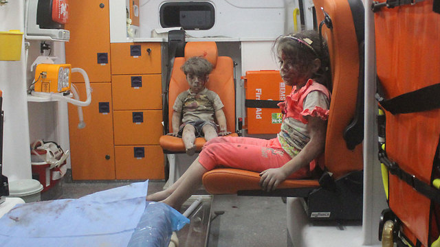 "רק אז הבנתי את גודל הטראומה של הילד". עומראן וילדה פצועה אחרת באמבולנס (צילום: רויטרס) (צילום: רויטרס)