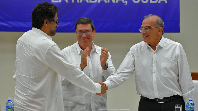 לחצו ידיים. הנציג הקולומביאני, שר החוץ של קובה ונציג המחתרת (צילום: AFP) (צילום: AFP)