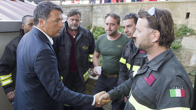 "יום של דמעות". ראש ממשלת איטליה רנצי נפגש עם אנשי כוחות החילוץ וההצלה (צילום: EPA) (צילום: EPA)