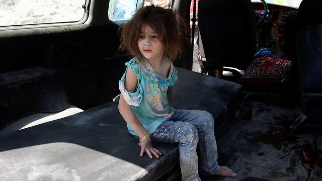 ילדה שחולצה מהלחימה בשכונת באב א-ניירב בחלב (צילום: רויטרס) (צילום: רויטרס)