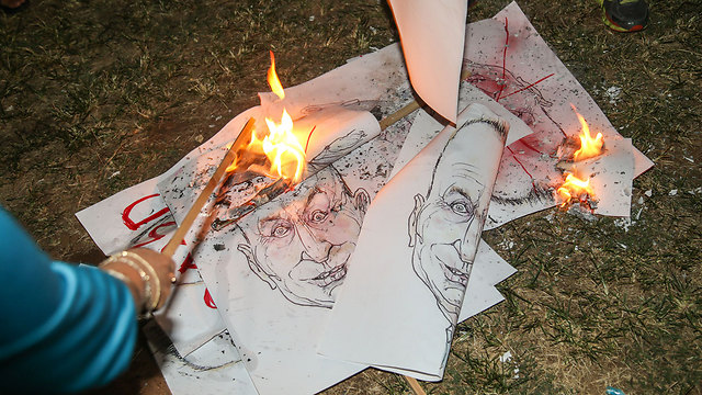 Protesters burn signs with the likeness of Mayor Huldai (Photo: Yariv Katz)