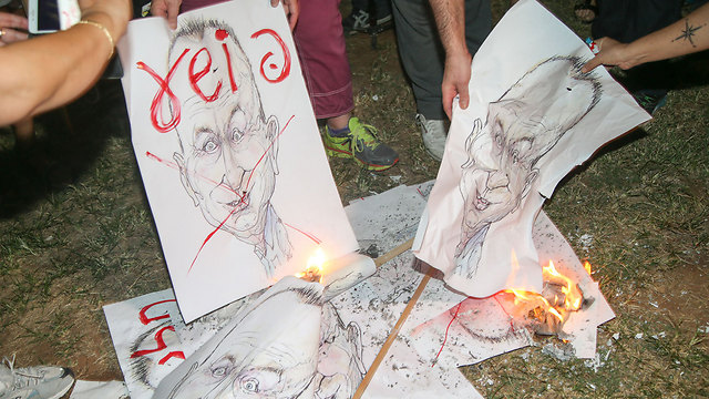 Protesters burn signs with the likeness of Mayor Huldai (Photo: Yariv Katz)