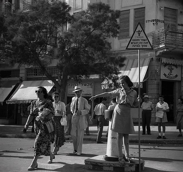 שיעור משמרות זהירות, ילדה המכוונת את התנועה בכיכר ב' בנובמבר, צומת הרחובות אלנבי ובן יהודה. תל אביב, 1949 (צילום: הנס פין, לע"מ)