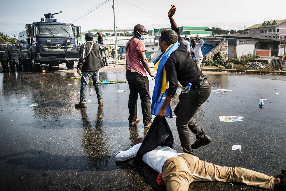 Gabonese opposition supporter lies on the ground injured (Photo: AFP)