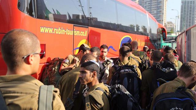 Soldiers crowding around shuttle buses in Tel Aviv (Photo: Motti Kimchi)
