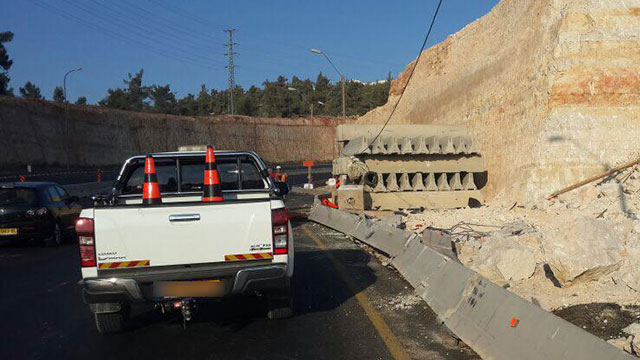 ערימה של מעקות בטון שהונחה בצורה מסוכנת בשולי הכביש  ()