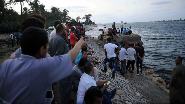 People waiting for more bodies to be offloaded (Photo: Reuters)
