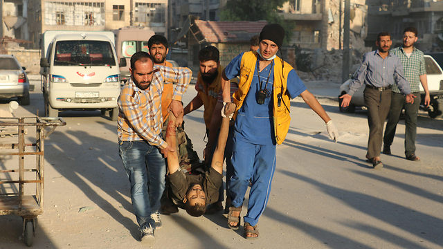 Wounded man carried to safety in the bombed Syrian city. (Photo: AFP)