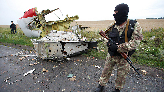 A Russian affiliated rebel next to wreckage from the downed MH17 flight (Photo: Reuters)
