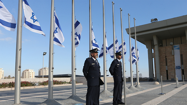 Knesset Guard members standing at attention while flags are lowered to half-staff in honor of Shimon Peres (Photo: Alex Kolomoisky)