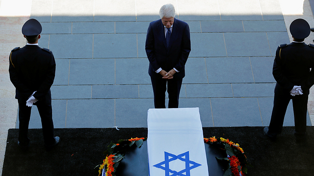 Clinton stands before Peres' casket (Reuters)