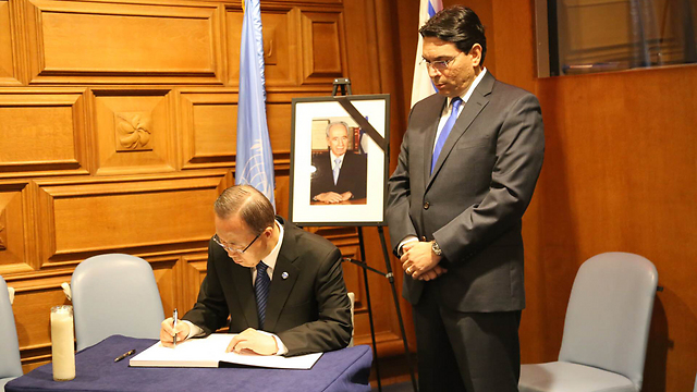 Ban Ki-moon signs book of condolence as Danny Danon looks on