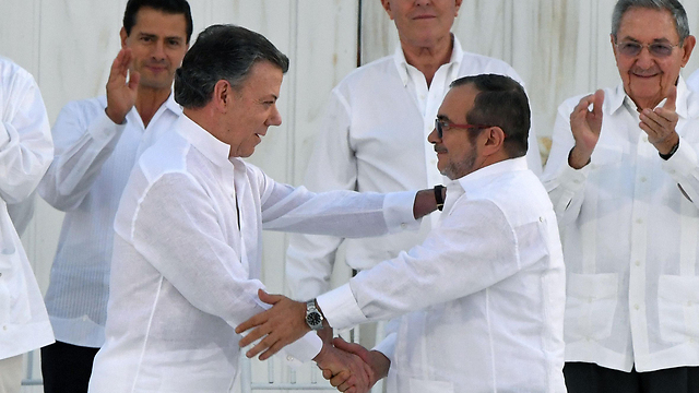 President Santos shaking hands with the head of the FARC guerrilla Timoleon Jimenez, aka Timochenko (Photo: AFP) (Photo: AFP)