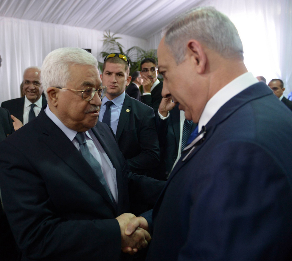 Abbas (L) and Netanyahu shake hands at Shimon Peres' funeral (Photo: Amos Ben Gershom/GPO)