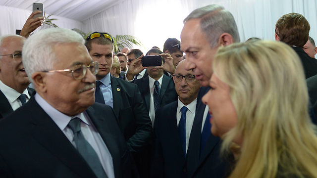 Palestinian President Mahmoud Abbas, left, and Prime Minister Benjamin Netanyahu meeting at Shimon Peres' funeral in Jerusalem, September 2016 (Photo: GPO)