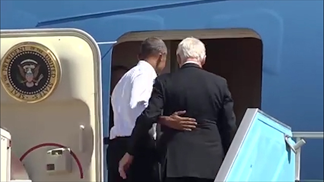 Obama and Clinton walk into Air Force One, on their way back to the US