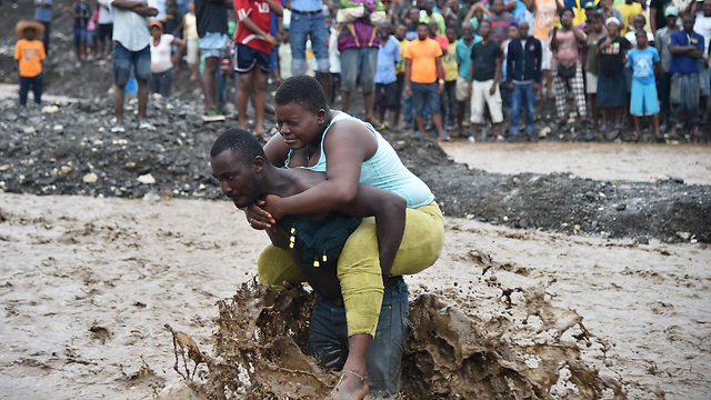 Crossing a river by foot, after a bridge collapsed in Haiti (Photo: AFP) (Photo: AFP)