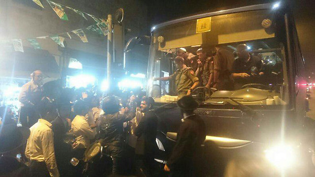 Soldiers descend from bus to a furious Haredi crowd (Photo: Sahar Almog)