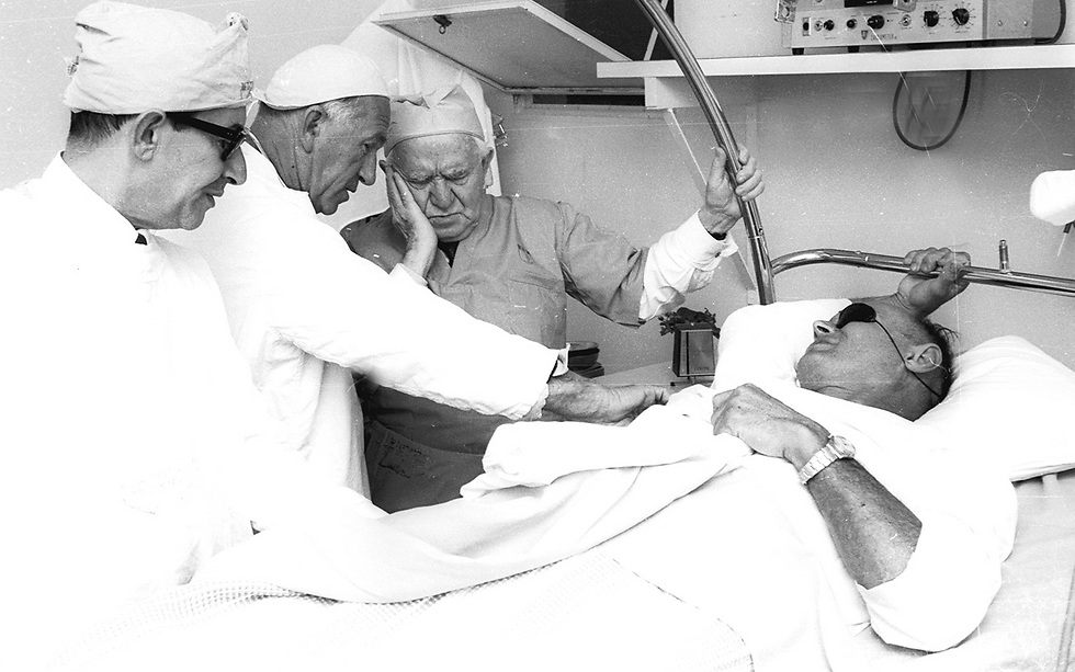 Former Israeli prime minister David Ben-Gurion visits then defense minister Moshe Dayan after the latter was injured during an archeological dig, March 1968 (Photo: Dan Hadani, of the IPPA collection)
