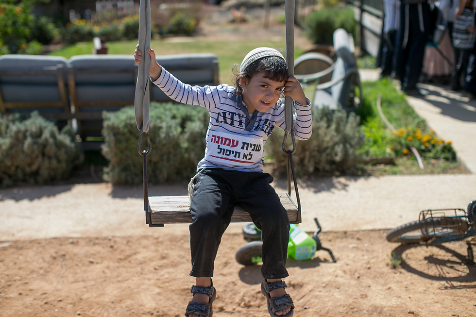 A child in Ofra with a sticker on his shirt saying 'Ofra will not fall again' (Photo: Ohad Zwigenberg)