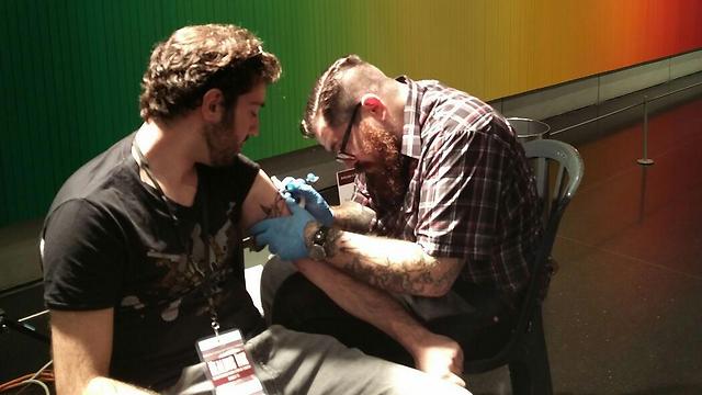 Maor David getting two doves tattooed on his arm (Photo: Yael Freidson)