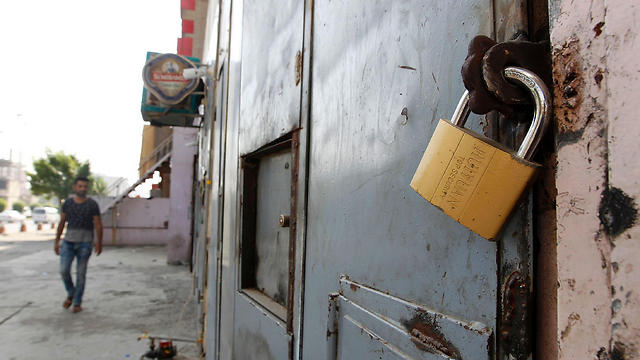 An Iraqi man walks past a closed liquor store in the capital Baghdad on October 23. (Photo: AP)