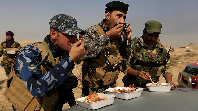 Soldiers take ime to eat as they fight ISIS outside of Mosul (Photo: Reuters)