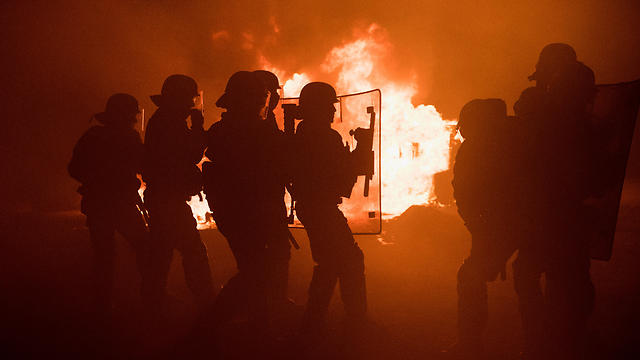 שוטרים על רקע להבות, הלילה בקאלה (צילום: GETTYIMAGES)