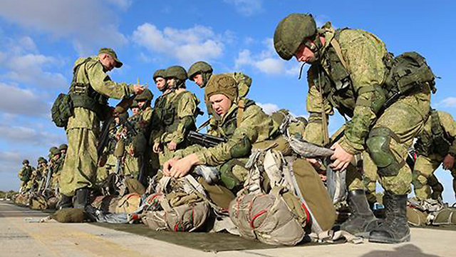 Russian paratroopers prepare their parachutes