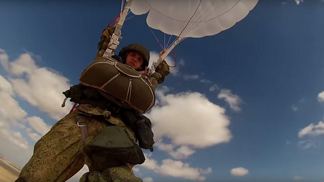 A Russian paratroopers floats down to the ground