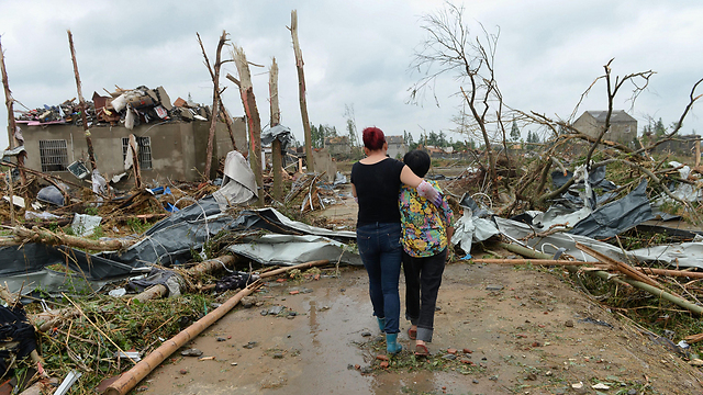 A woman, who lost her nine-year-old grandson during the tornado, is comforted by another woman in Funing County, China. (Photo: EPA)