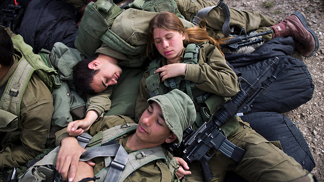 IDF soldiers of the mixed-gender Bardelas Battalion relaxing between exercises outside of Regavim (Photo: EPA)