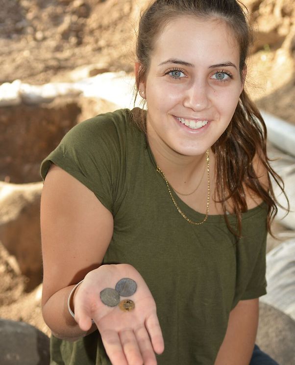 דור יגב, חניכת מכינת "גליל עליון", עם מטבעות שנחשפו בחפירה (צילום: גלעד צינמון, באדיבות רשות העתיקות)