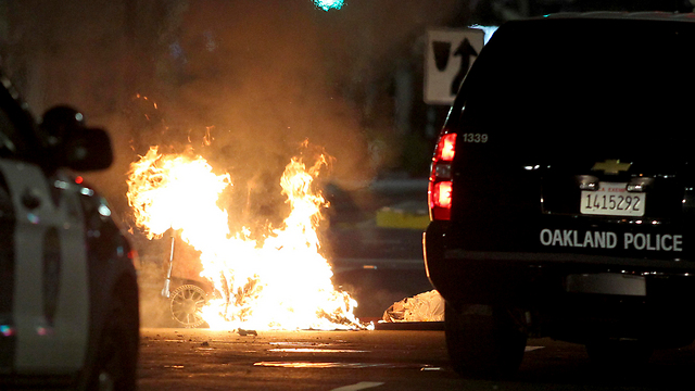 פח אשפה שהועלה באש באוקלנד, קליפורניה (צילום: AP) (צילום: AP)
