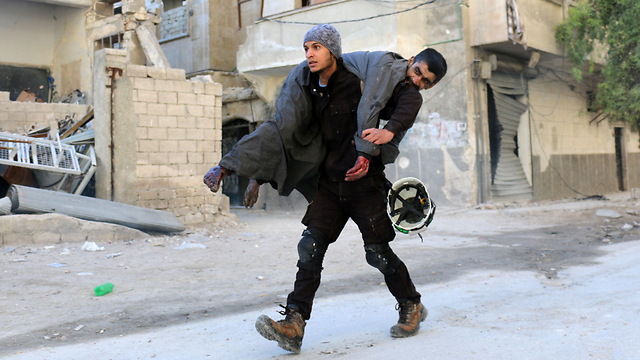 White Helmets activist rescuing a Syrian refugee in Aleppo  (Photo: AFP)
