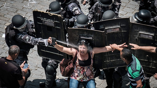 ישר לעיניים. עובדת במגזר הציבורי בריו דה ז'ניירו מפגינה נגד צעדי צנע (צילום: AFP) (צילום: AFP)