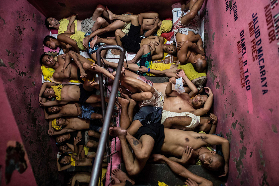 אסירים מצטופפים כדי לישון על גרם מדרגות בכלא במנילה, בירת הפיליפינים. בכלא הזה, בן עשרות שנים, הצפיפות אדירה, ואסירים נלחמים על כל חלל פנוי (צילום: AFP) (צילום: AFP)